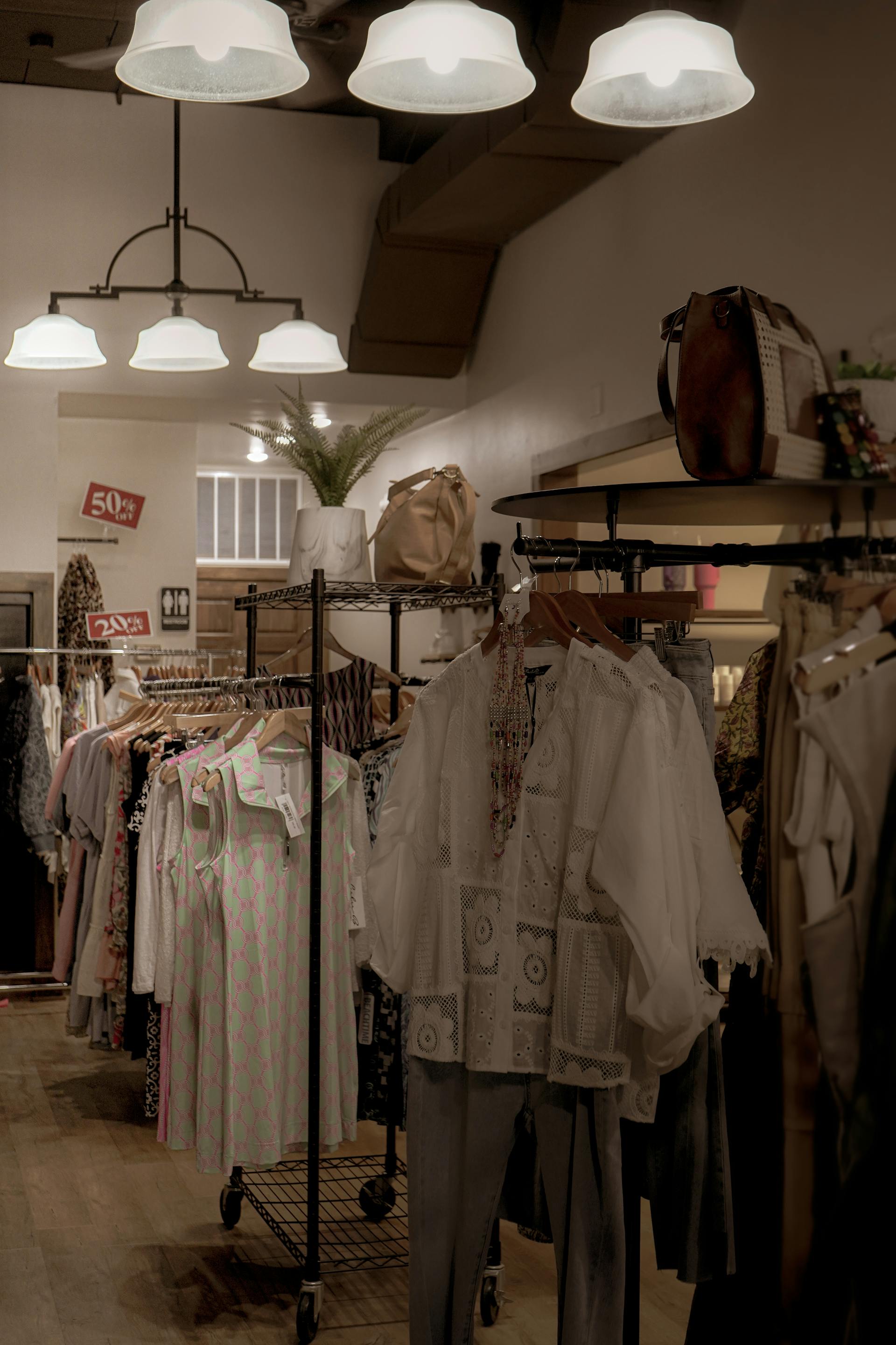 Warm boutique interior with clothing on wall-mounted racks