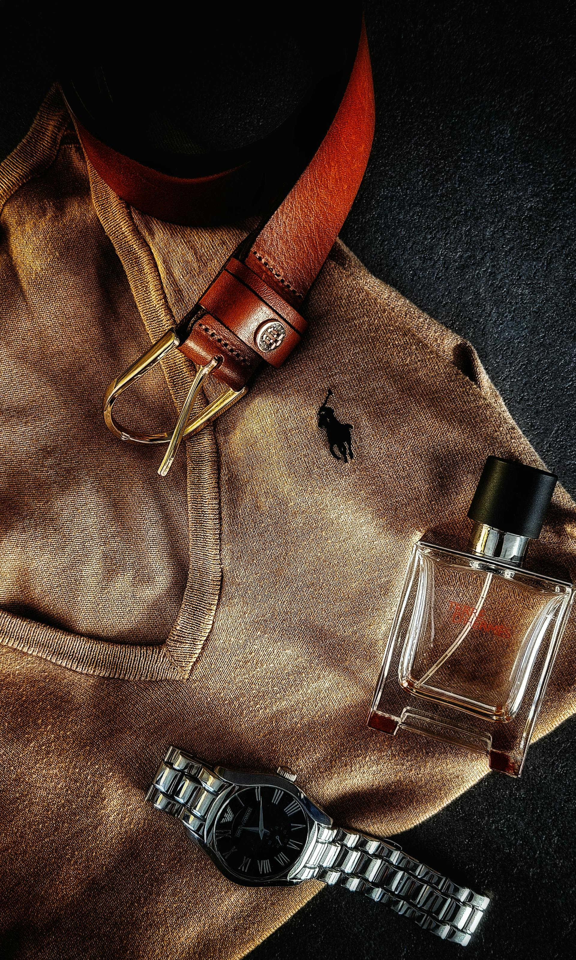 Leather belt and apparel accessories laid out as flatlay