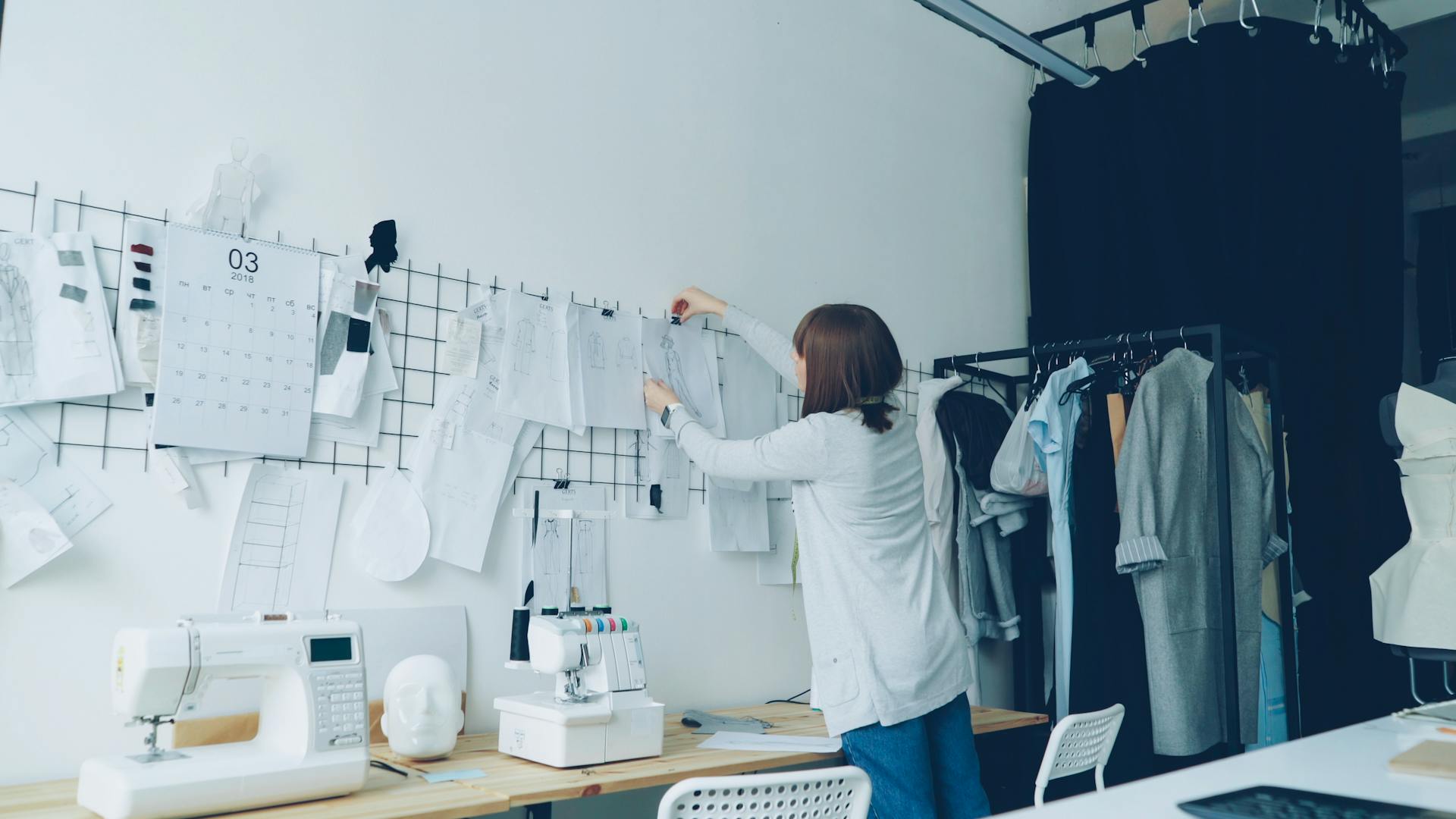 Designer organizing sketches on an inspiration board in a studio